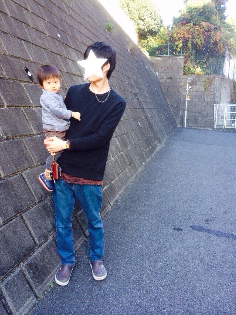 ブラック系のスウェット、ブラウン系のニット/セーター、ブルー系のデニムパンツを着用したメンズの秋コーディネートの1枚目の写真