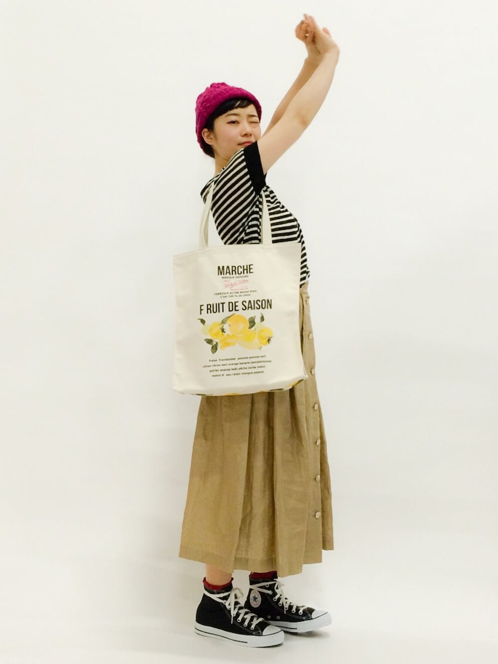 ブラック系のTシャツ/カットソー、ベージュ系のスカート、イエロー系のトートバッグを着用したレディースの春コーディネートの1枚目の写真