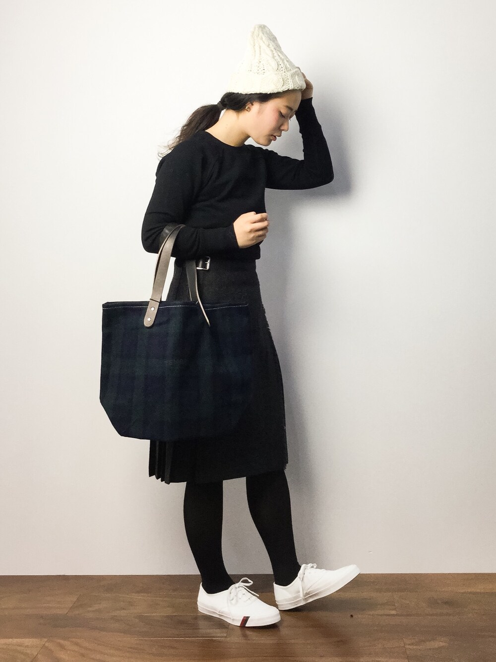 ブラック系のスウェット、グレー系のスカート、グリーン系のトートバッグを着用したレディースの秋コーディネートの1枚目の写真