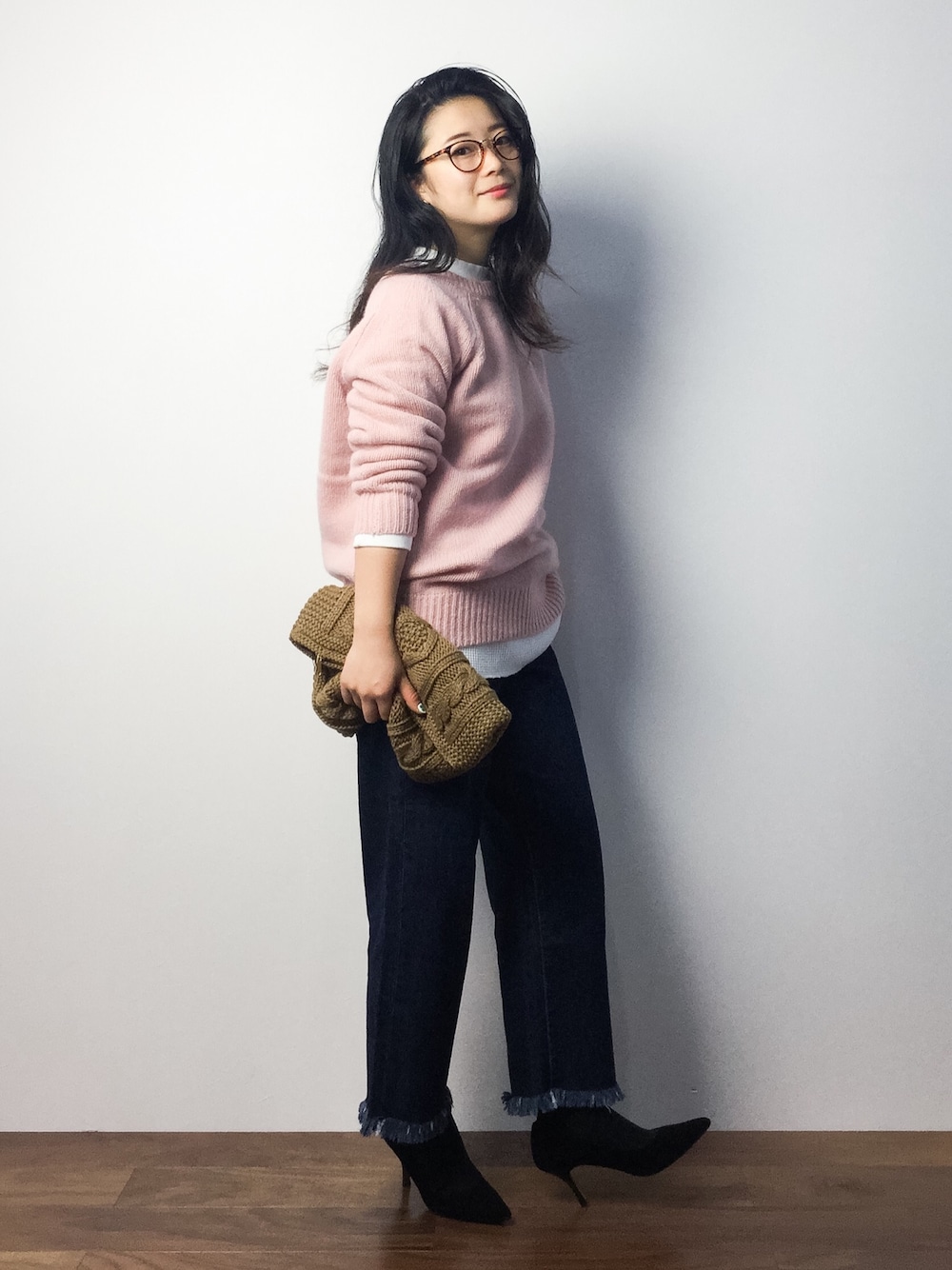 ピンク系のニット/セーター、ホワイト系のTシャツ/カットソー、ブラウン系のクラッチバッグを着用したレディースの秋コーディネートの1枚目の写真