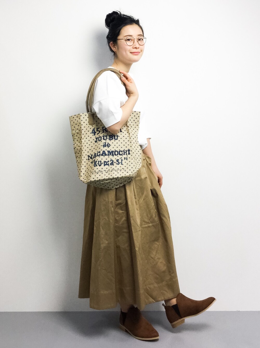 ホワイト系のTシャツ/カットソー、ベージュ系のスカート、その他のショルダーバッグを着用したレディースの冬コーディネートの1枚目の写真