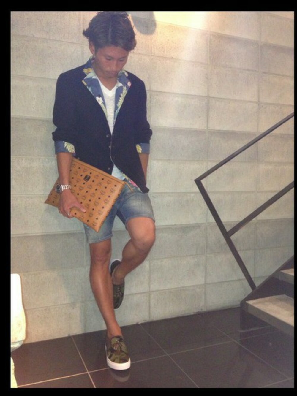 グリーン系のスニーカー、ブラウン系のポーチを着用したメンズの夏コーディネートの1枚目の写真