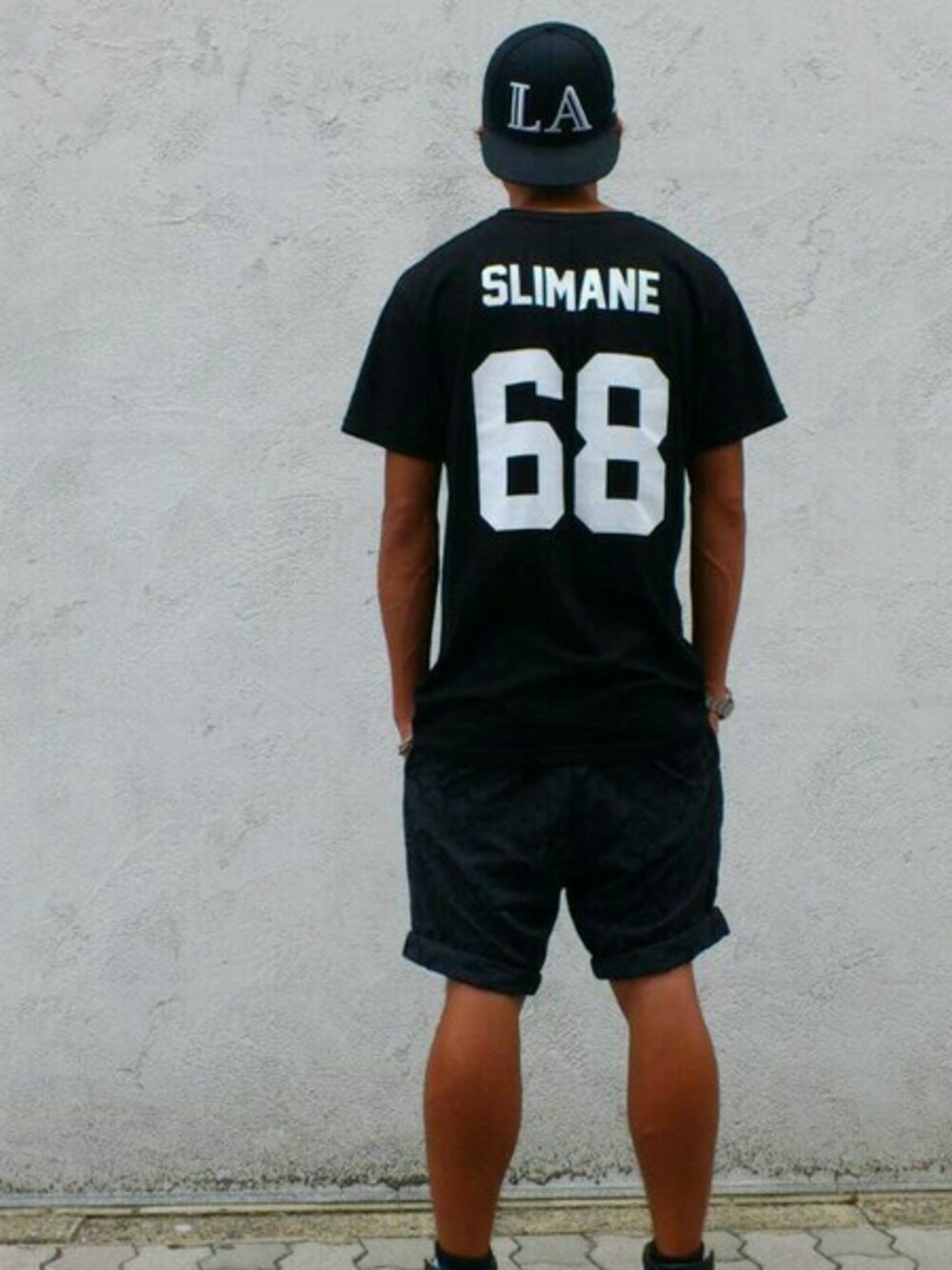 ブラック系のTシャツ/カットソーを着用したメンズの夏コーディネートの1枚目の写真