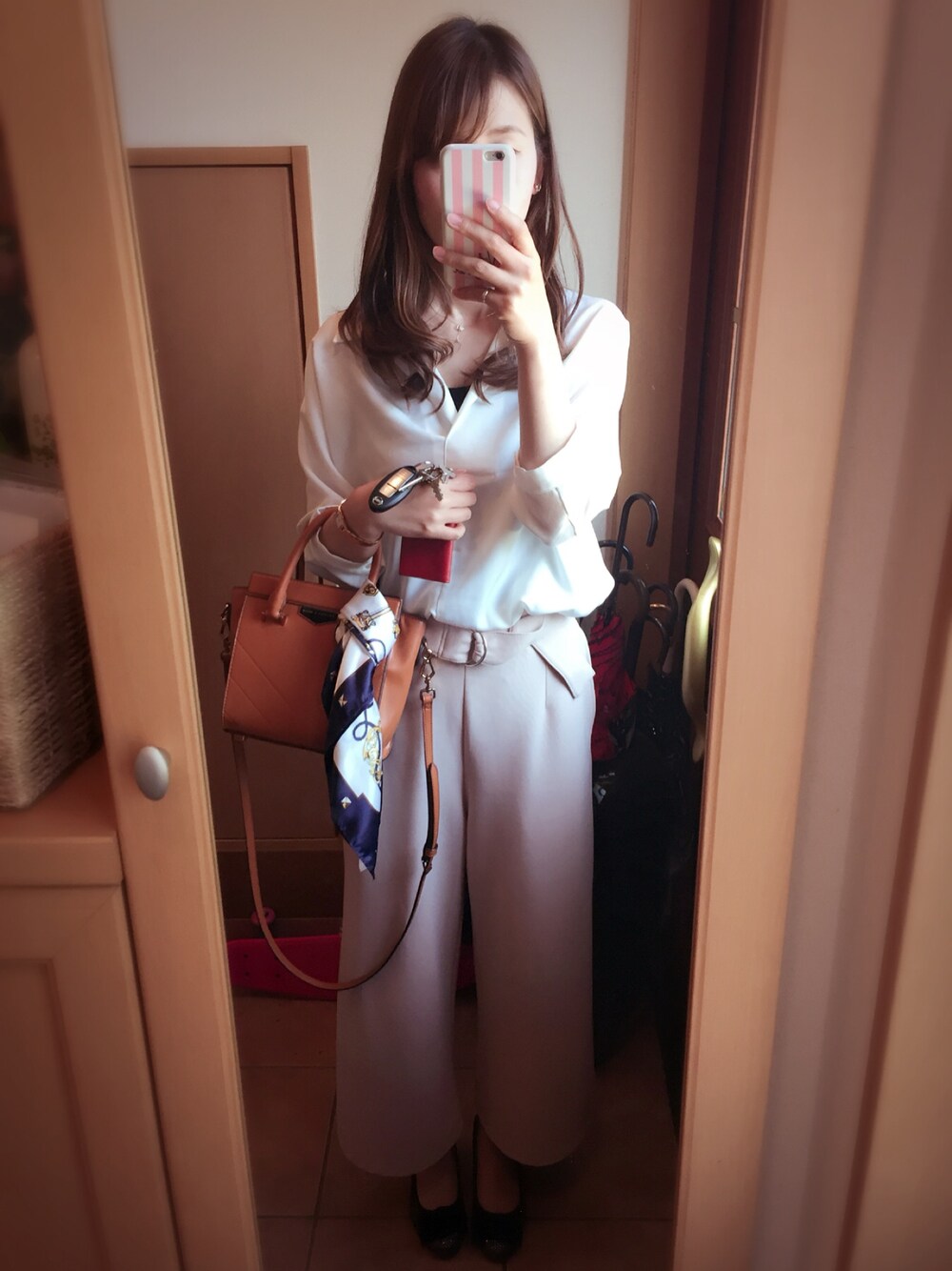 ベージュ系のその他パンツ、ホワイト系のシャツ/ブラウス、ブラウン系のショルダーバッグを着用したレディースの春コーディネートの1枚目の写真