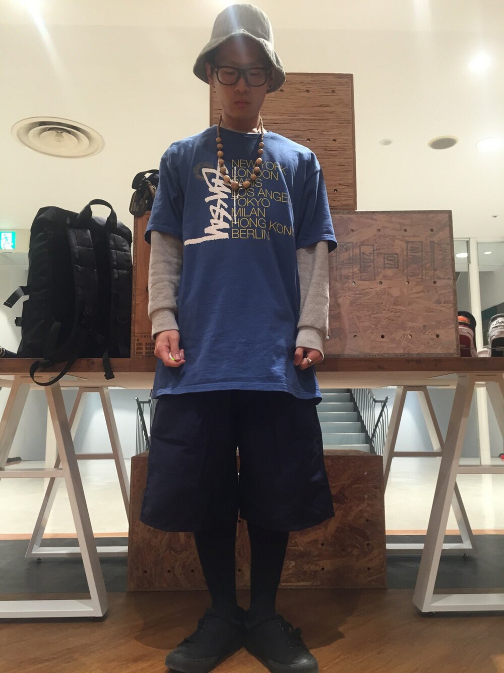 「ストリート、グルカパンツ、ミリタリー、レイヤードスタイル、バケットハット、めがね、古着、ハーフパンツ、ビッグT、ウッドアクセサリー」｜「STUSSYのアイテム（Tシャツ/カットソー、ブルー系）」を使った、柴田誠さん（メンズ・167cm）の春コーディネートの1枚目の写真