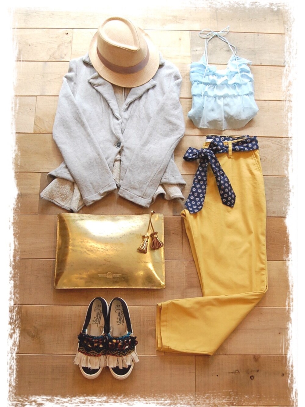 イエロー系のその他パンツ、ゴールド系のクラッチバッグ、ブラック系のスニーカーを着用したレディースの春コーディネートの1枚目の写真