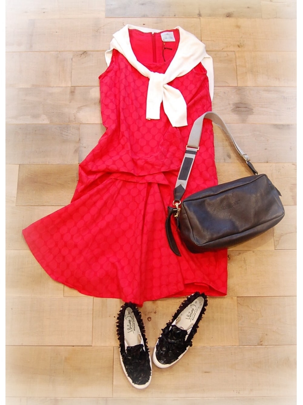 レッド系のワンピース、ブラック系のショルダーバッグ、ブラック系のスニーカーを着用したレディースの夏コーディネートの1枚目の写真