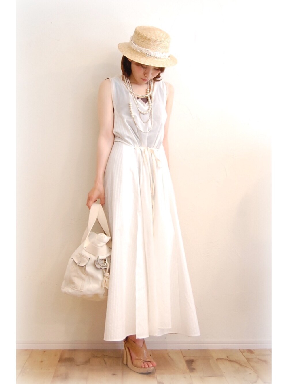 ホワイト系のワンピース、ホワイト系のトートバッグ、ベージュ系のハットを着用したレディースの夏コーディネートの1枚目の写真