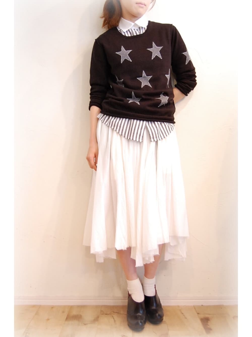 ブラック系のニット/セーター、ブラック系のシャツ/ブラウス、グレー系のワンピースを着用したレディースの秋コーディネートの1枚目の写真