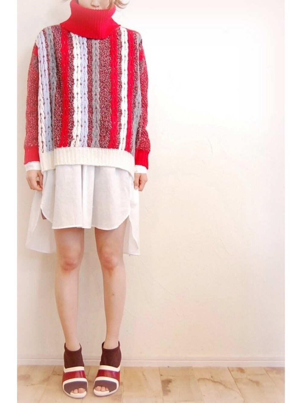 レッド系のニット/セーター、ホワイト系のシャツ/ブラウス、レッド系のブーティを着用したレディースの秋コーディネートの1枚目の写真