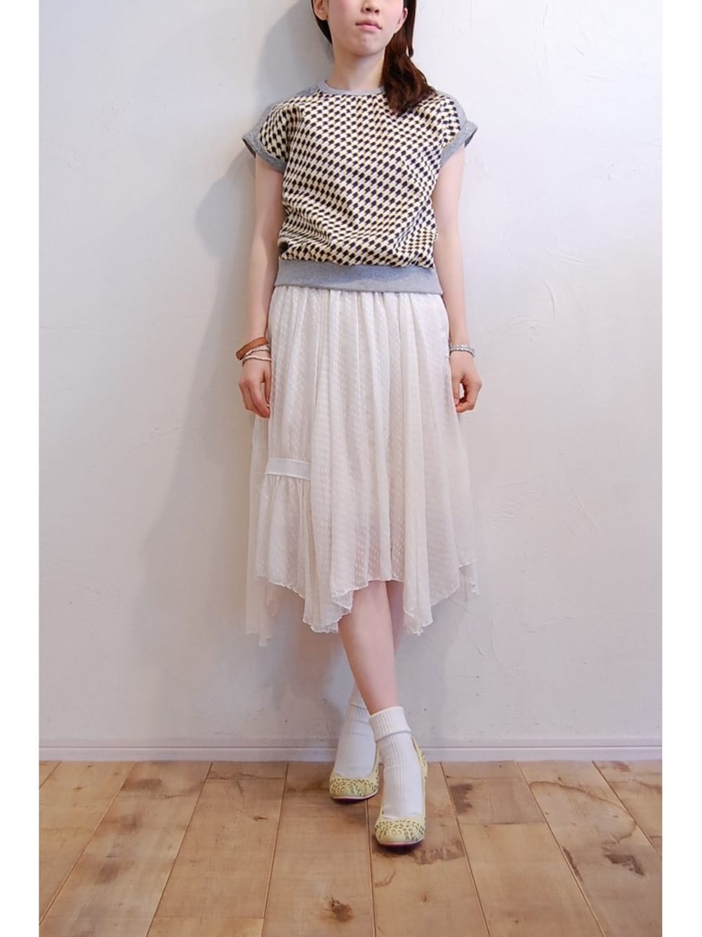 グレー系のTシャツ/カットソー、ホワイト系のスカート、イエロー系のパンプスを着用したレディースの春コーディネートの1枚目の写真