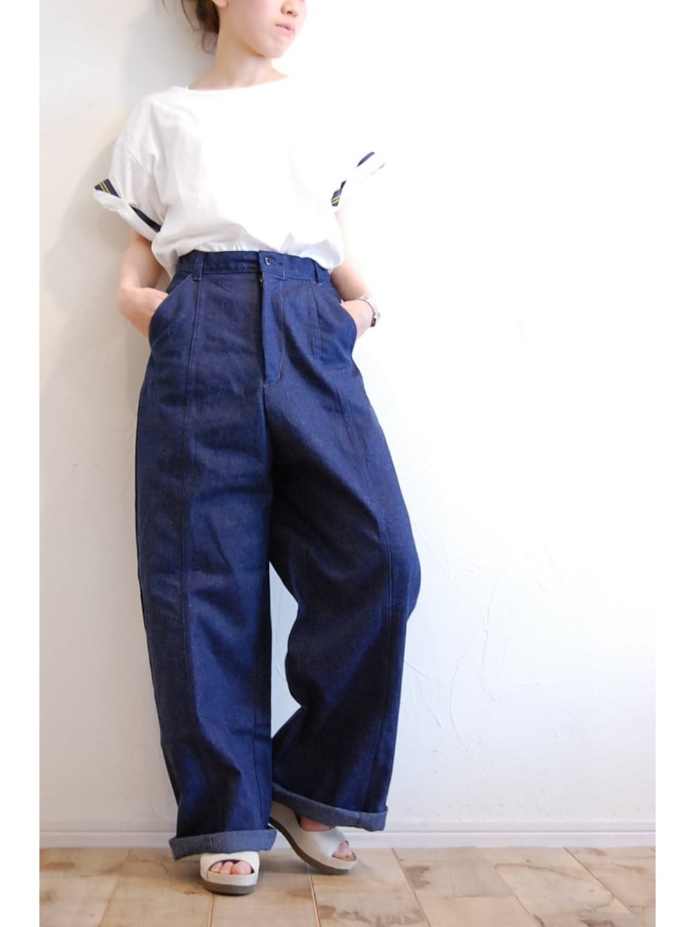 ブルー系のデニムパンツ、ホワイト系のTシャツ/カットソー、ブラウン系のサンダルを着用したレディースの春コーディネートの1枚目の写真