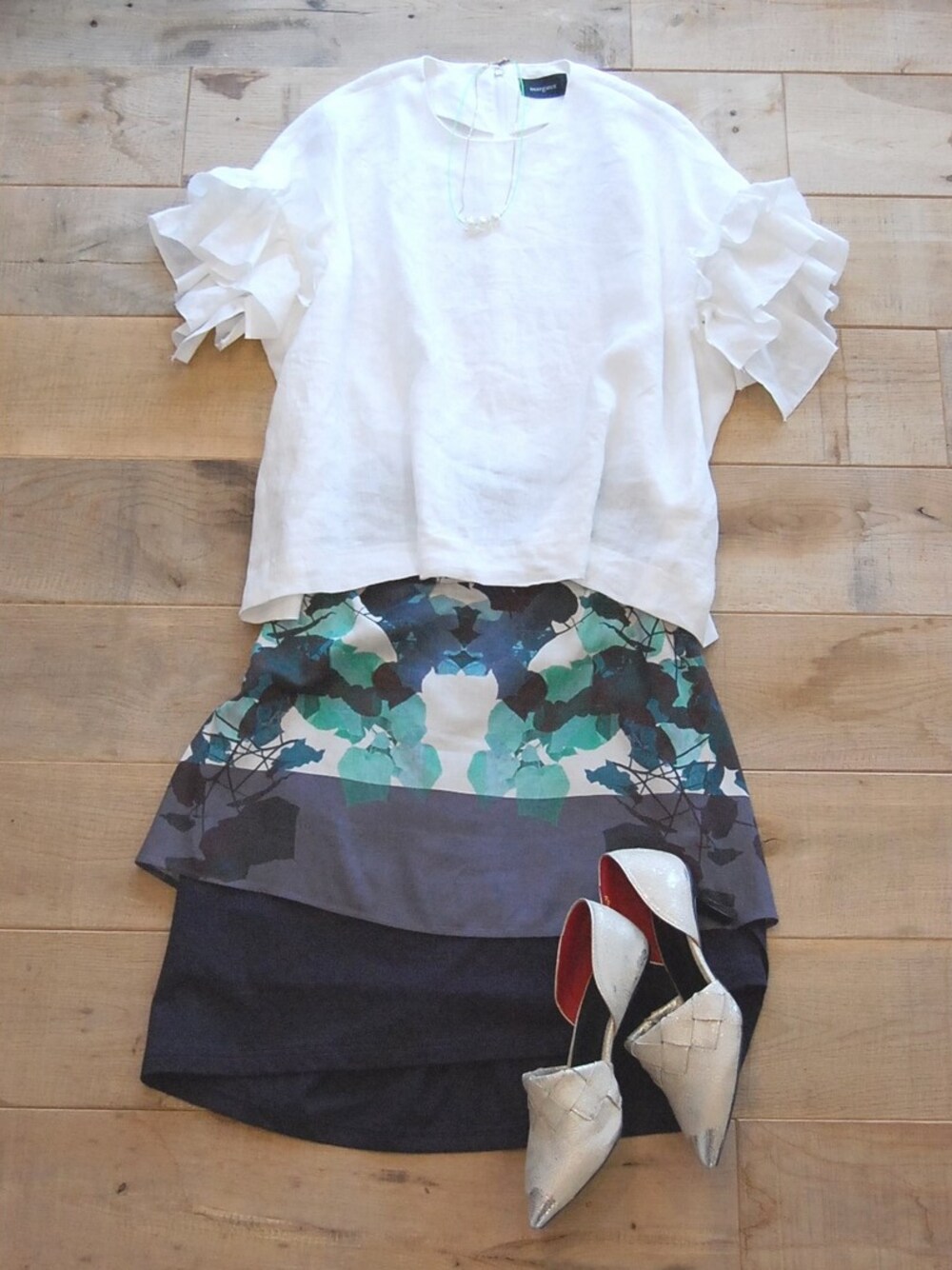 ブルー系のスカート、シルバー系のパンプス、ホワイト系のシャツ/ブラウスを着用したレディースの夏コーディネートの1枚目の写真