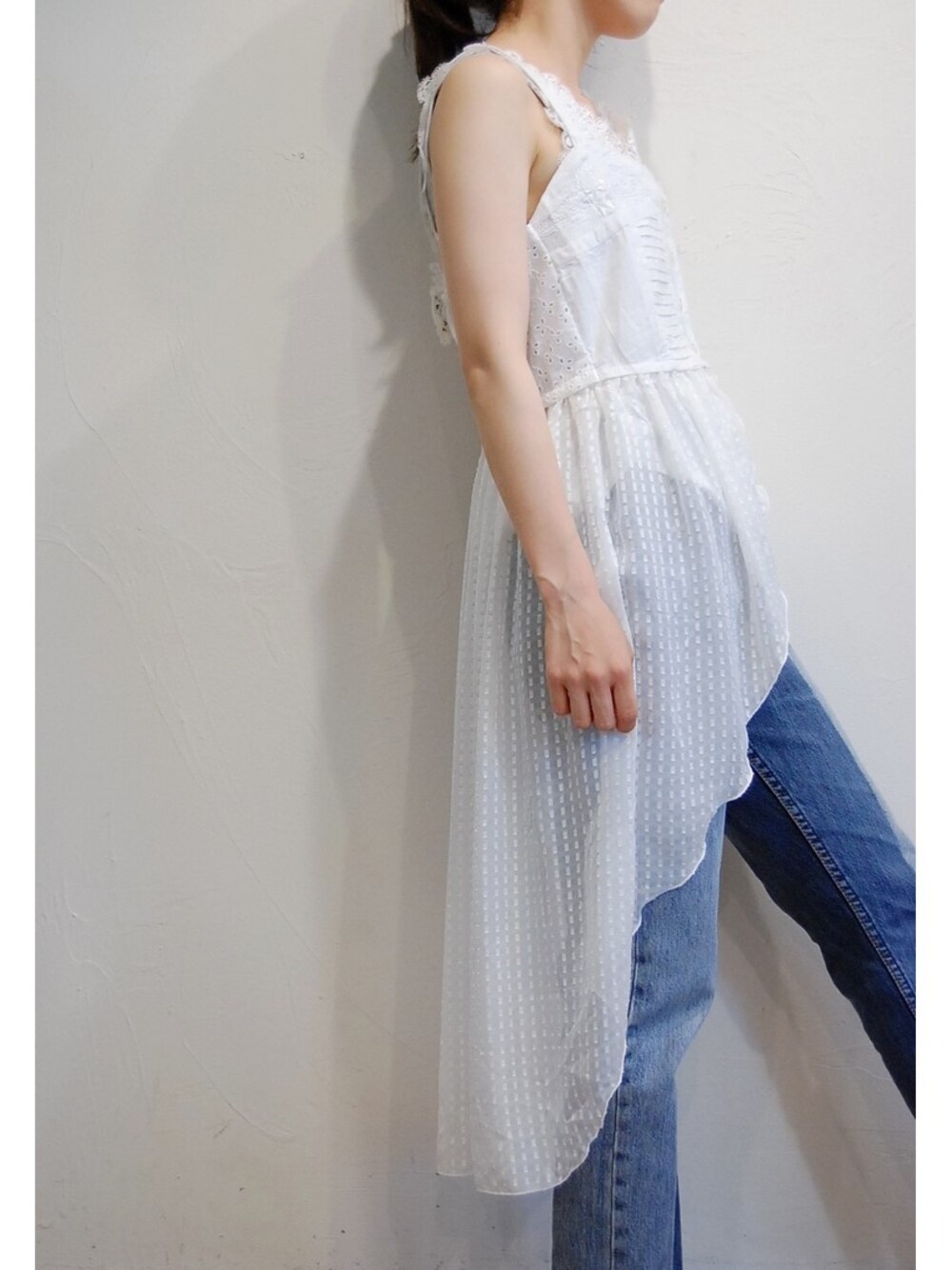 ホワイト系のキャミソール、ブルー系のデニムパンツ、ホワイト系のタンクトップを着用したレディースの夏コーディネートの1枚目の写真