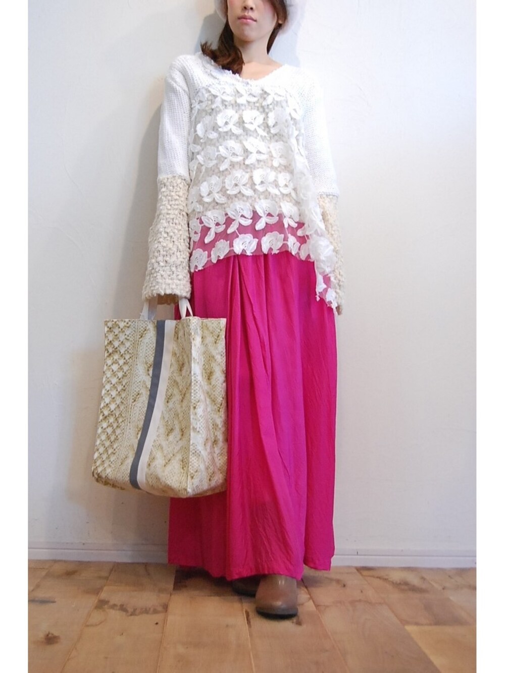 ホワイト系のニット/セーター、ピンク系のスカート、グレー系のブーツを着用したレディースの秋コーディネートの1枚目の写真