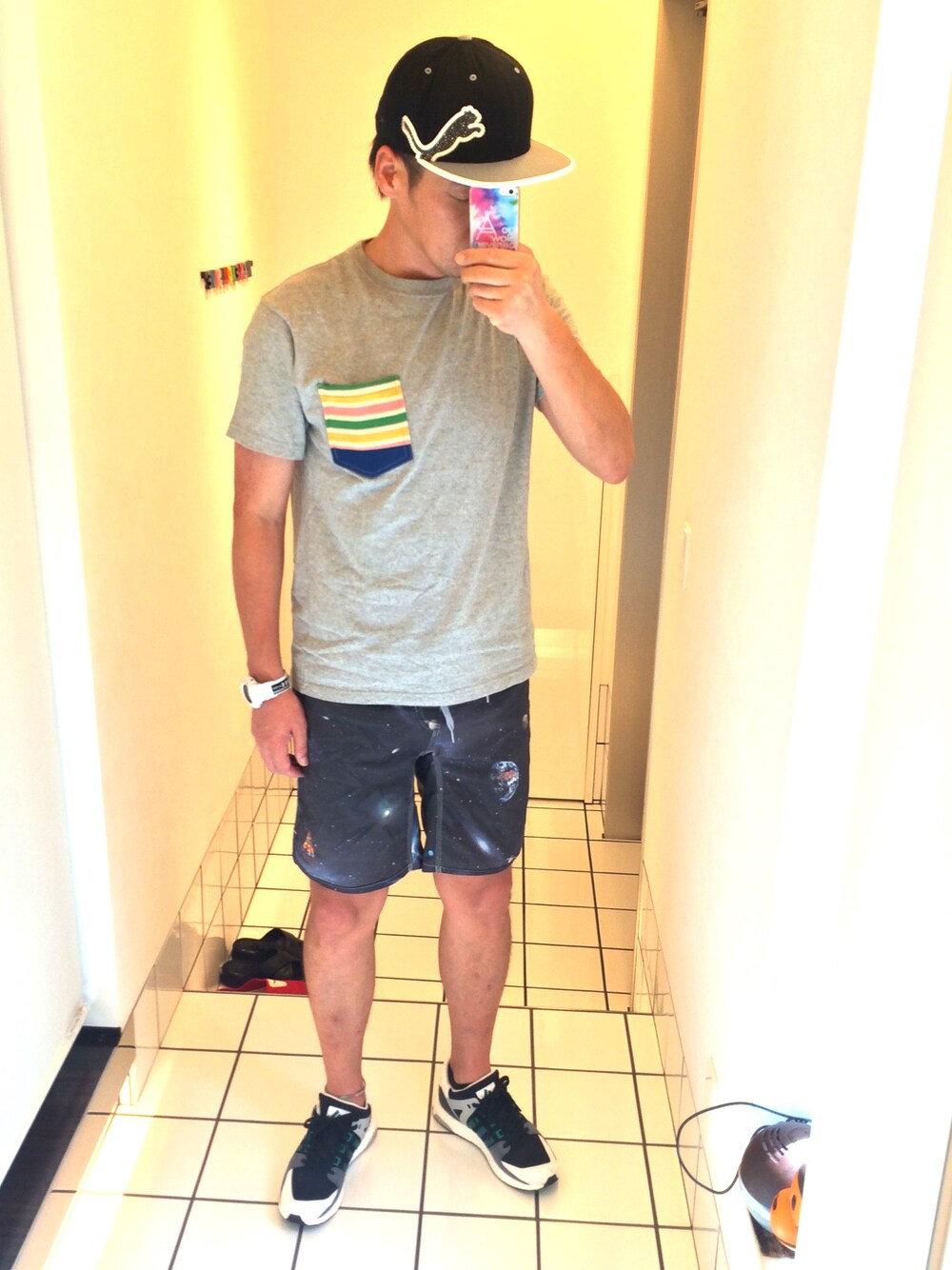 グレー系のTシャツ/カットソー、ブラック系のスニーカー、ブラック系のキャップを着用したメンズの夏コーディネートの1枚目の写真