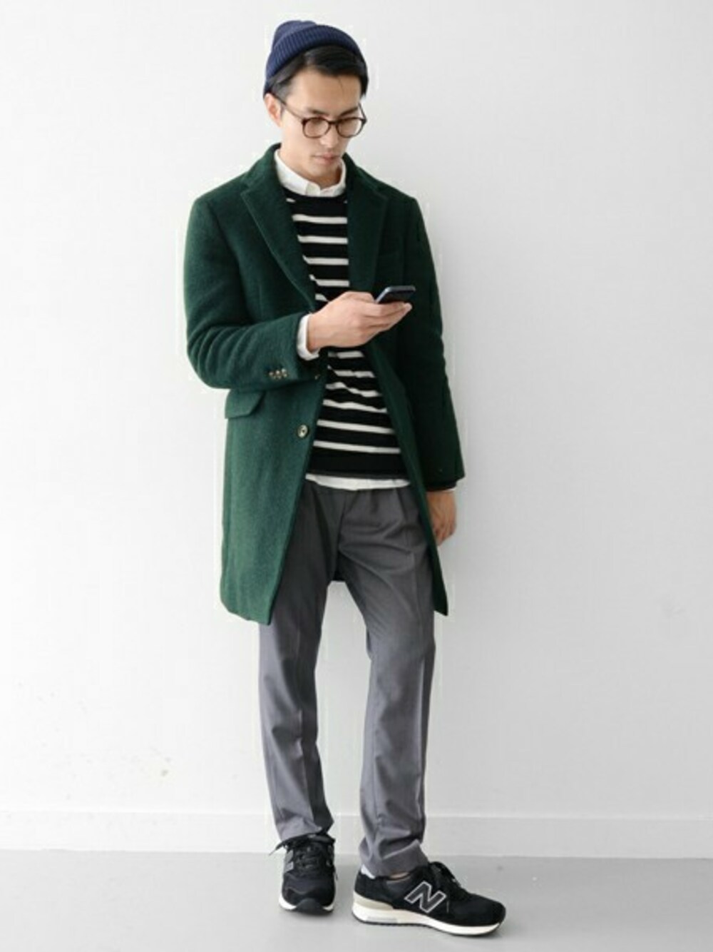 グリーン系のステンカラーコート、グレー系のスラックス、ブラック系のニット/セーターを着用したメンズの秋コーディネートの1枚目の写真