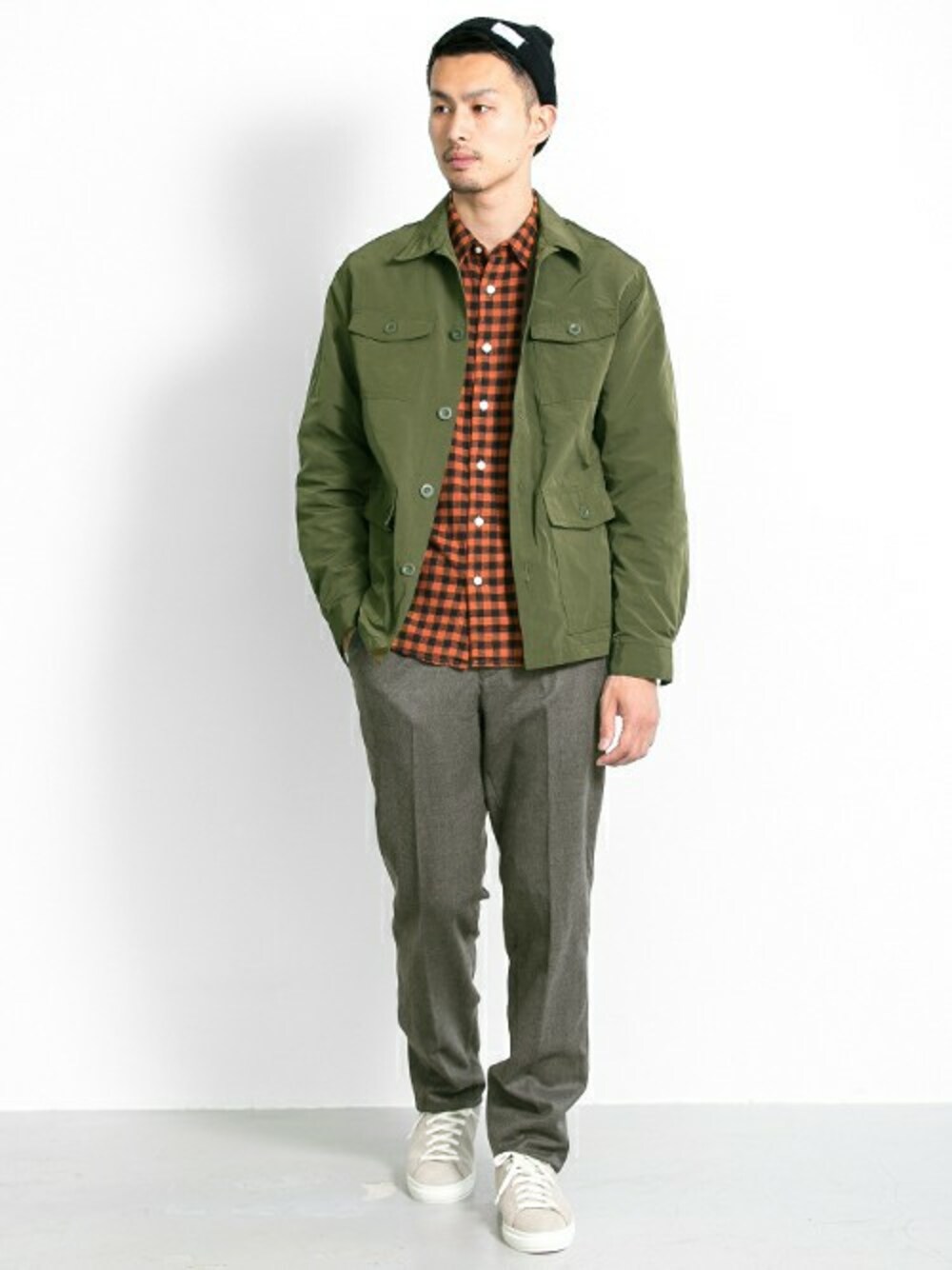 グリーン系のミリタリージャケット、オレンジ系のシャツ/ブラウス、グレー系のスラックスを着用したメンズの秋コーディネートの1枚目の写真