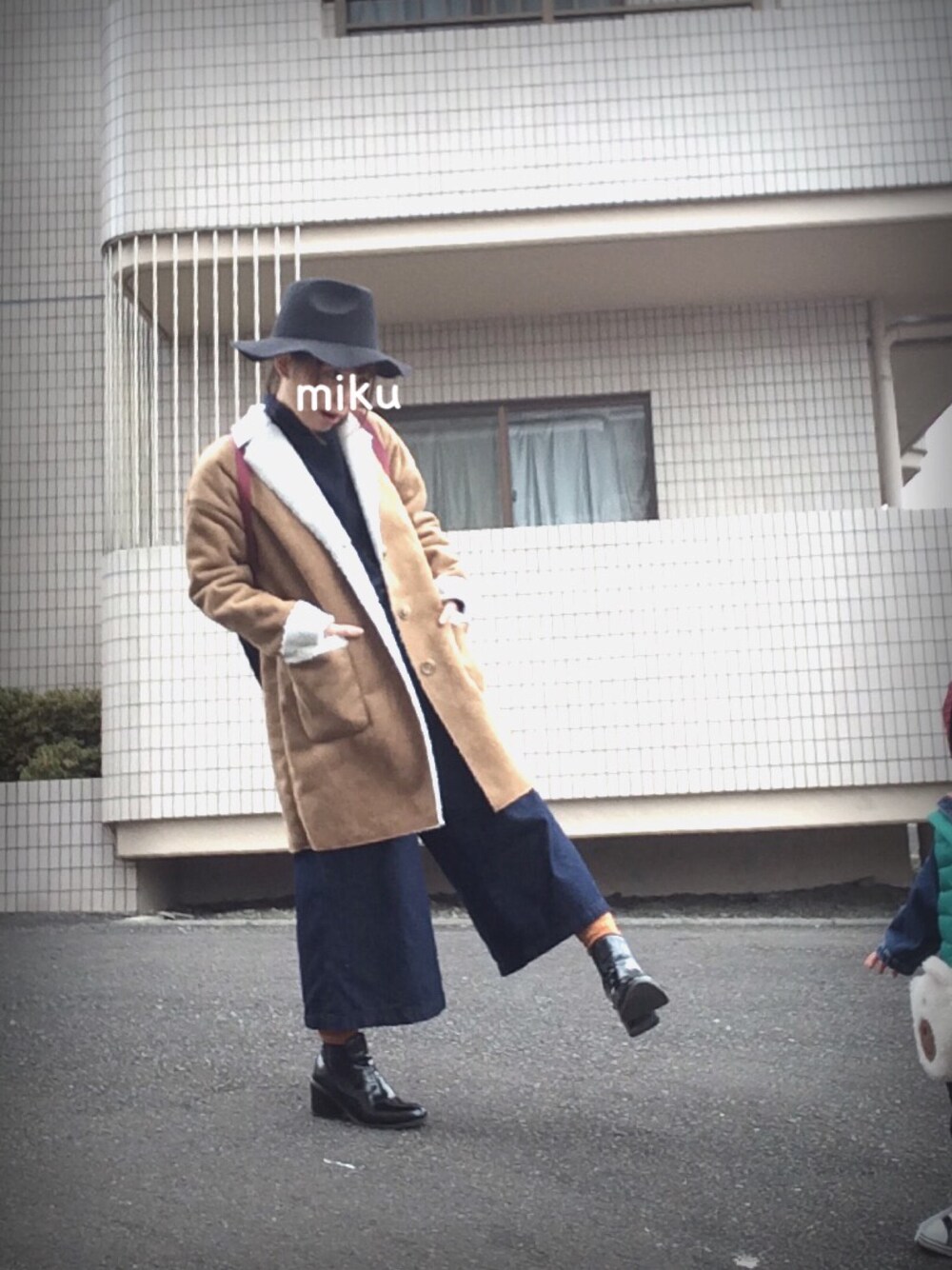 ブラック系のブーツ、ブルー系のニット/セーター、ベージュ系のムートンコートを着用したレディースの冬コーディネートの1枚目の写真