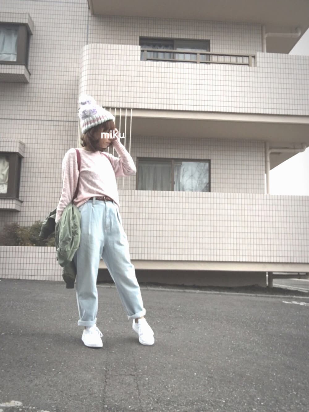 ピンク系のニット/セーター、ブルー系のデニムパンツ、ホワイト系のスニーカーを着用したレディースの冬コーディネートの1枚目の写真