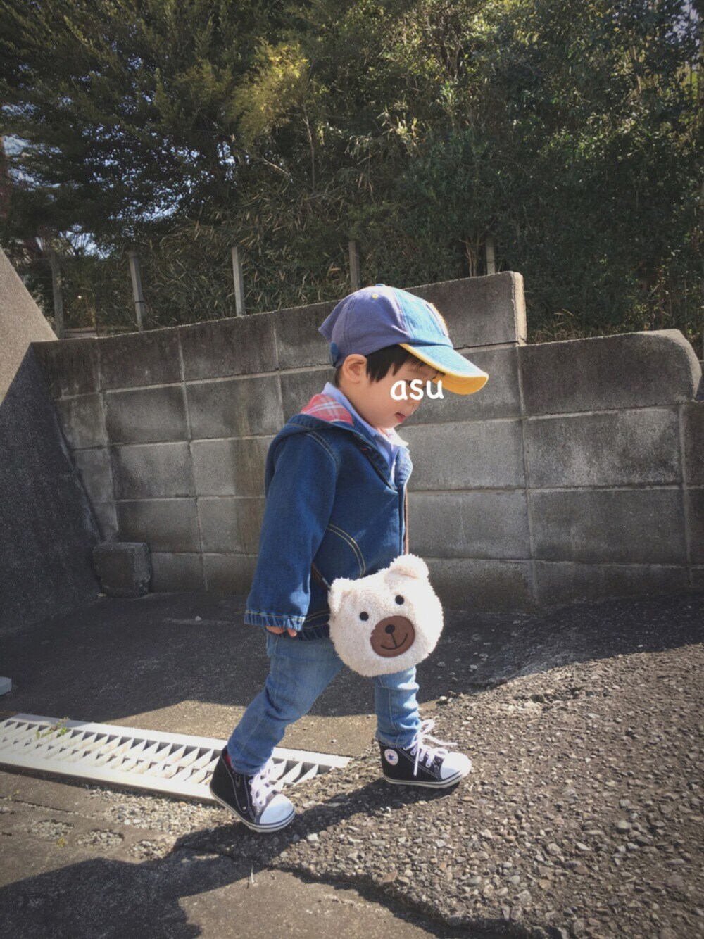 ブルー系のデニムジャケット、ベージュ系のバッグ、ブルー系のデニムパンツを着用したキッズの冬コーディネートの1枚目の写真