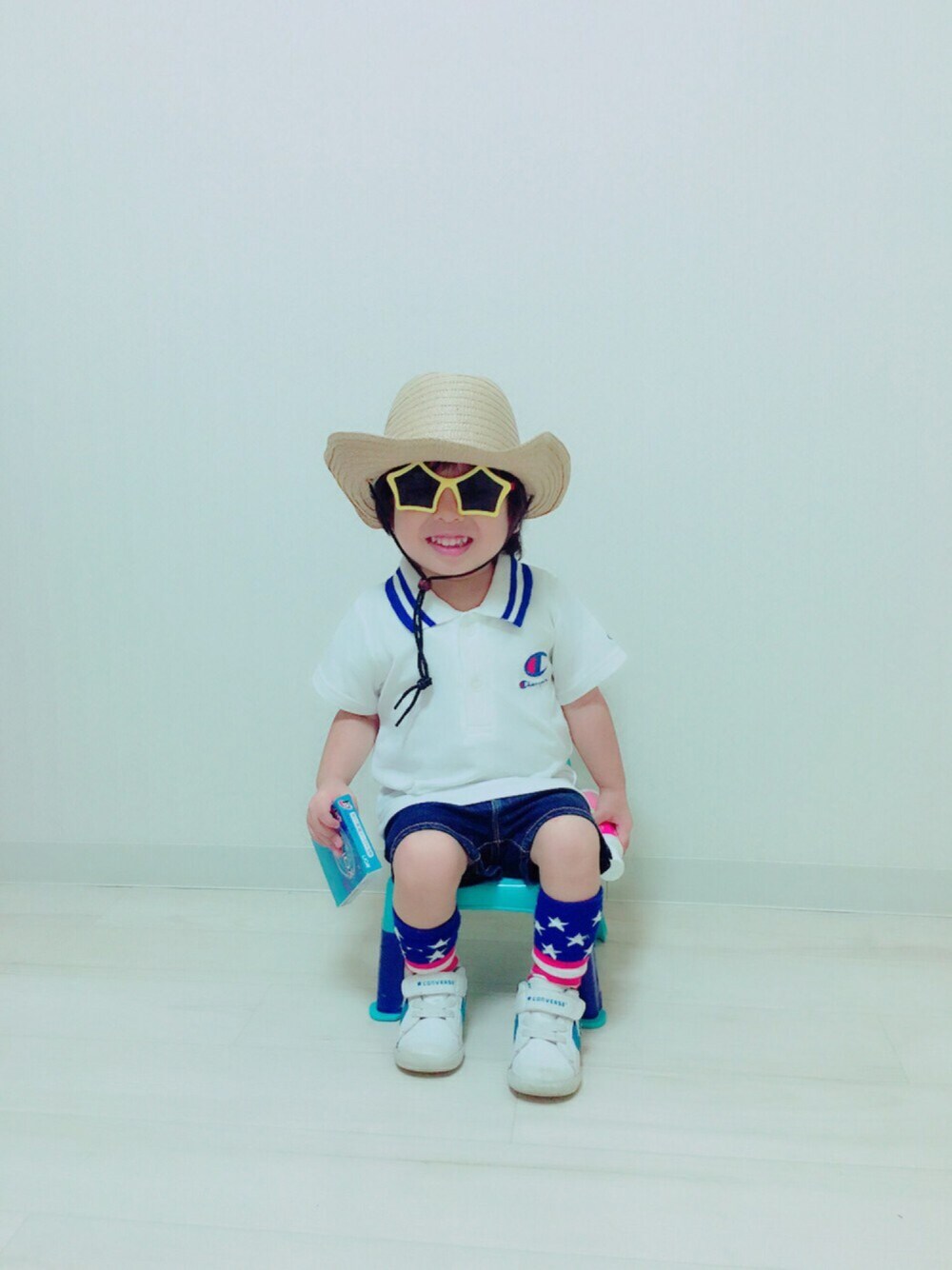 ホワイト系のポロシャツ、ブルー系のその他パンツ、ホワイト系のスニーカーを着用したキッズの夏コーディネートの1枚目の写真