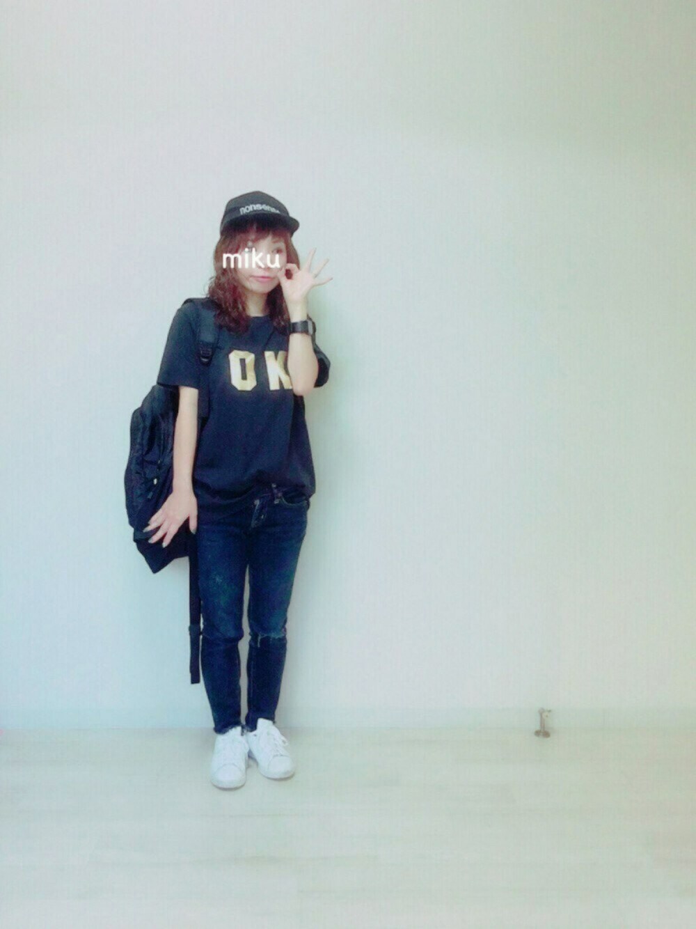 ブルー系のデニムパンツ、ホワイト系のスニーカー、ブラック系のバックパック/リュックを着用したレディースの秋コーディネートの1枚目の写真