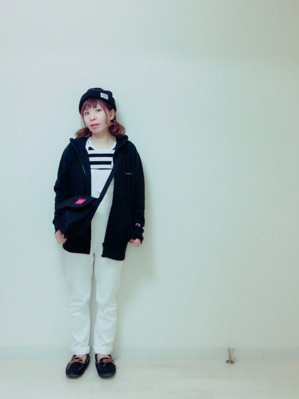 ブラック系のパーカー、ホワイト系のサロペット/オーバーオール、ブラック系のモカシン/デッキシューズを着用したレディースの秋コーディネートの1枚目の写真