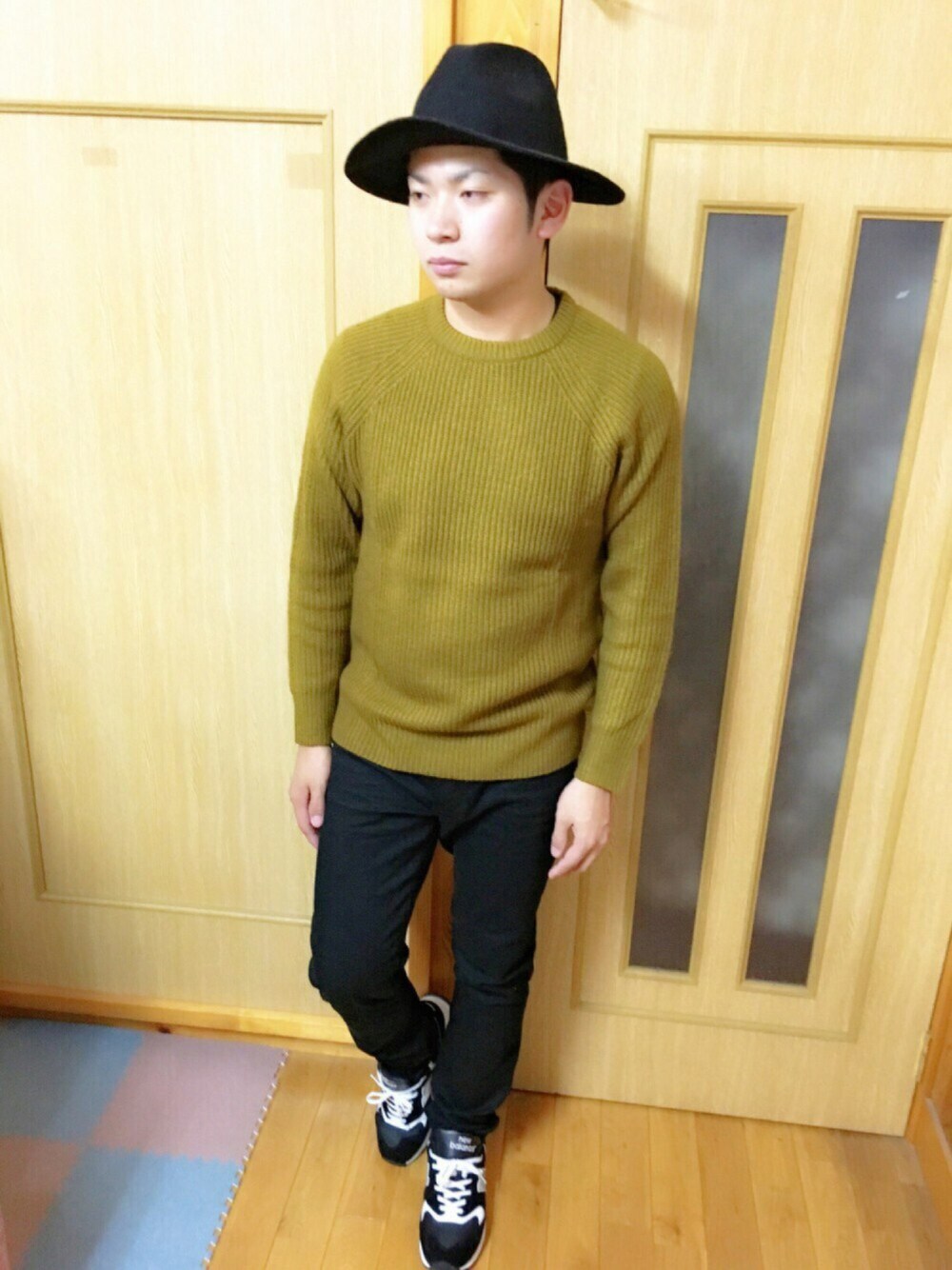 ブラック系のチノパンツ、イエロー系のニット/セーター、ブラック系のスニーカーを着用したメンズの秋コーディネートの1枚目の写真