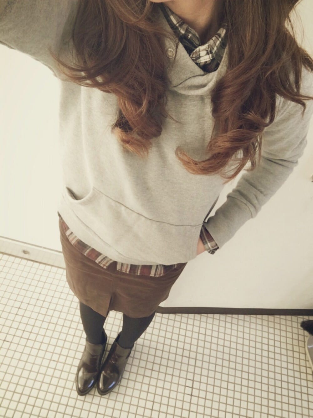 ブラウン系のシャツ/ブラウス、グレー系のパーカー、ブラウン系のスカートを着用したレディースの冬コーディネートの1枚目の写真