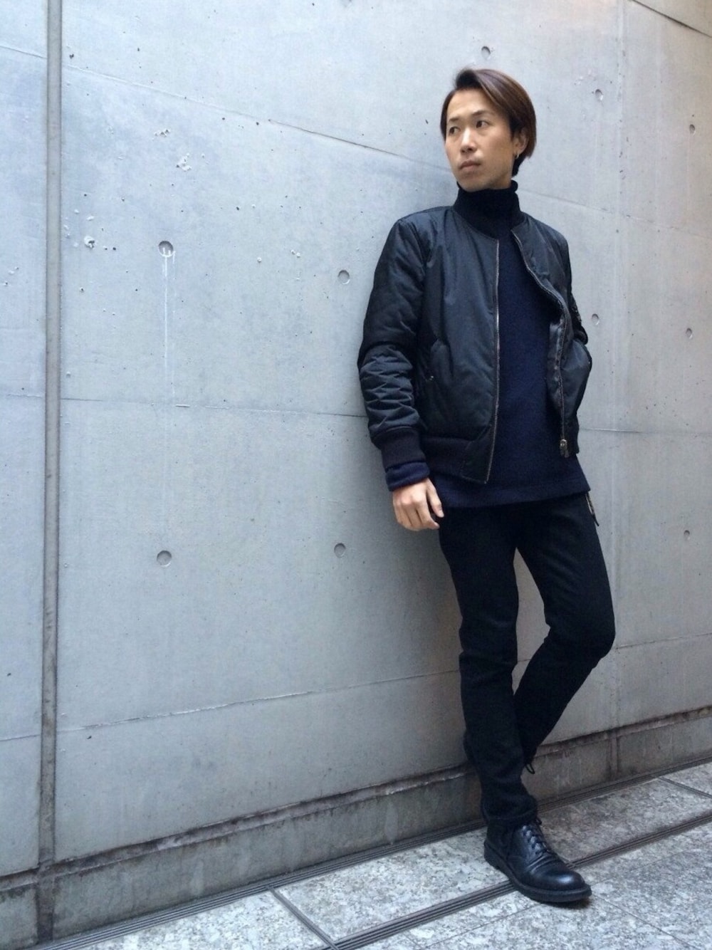 ブラック系のミリタリージャケット、ブラック系のブーツ、ブルー系のTシャツ/カットソーを着用したメンズの冬コーディネートの1枚目の写真