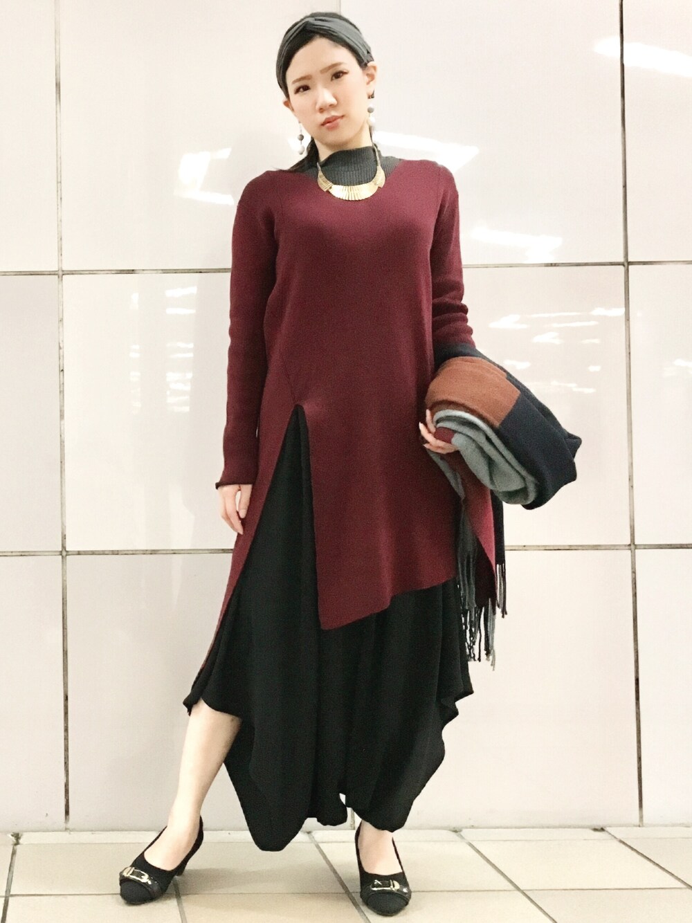 グレー系のニット/セーター、レッド系のニット/セーター、ブラック系のその他パンツを着用したレディースの秋コーディネートの1枚目の写真