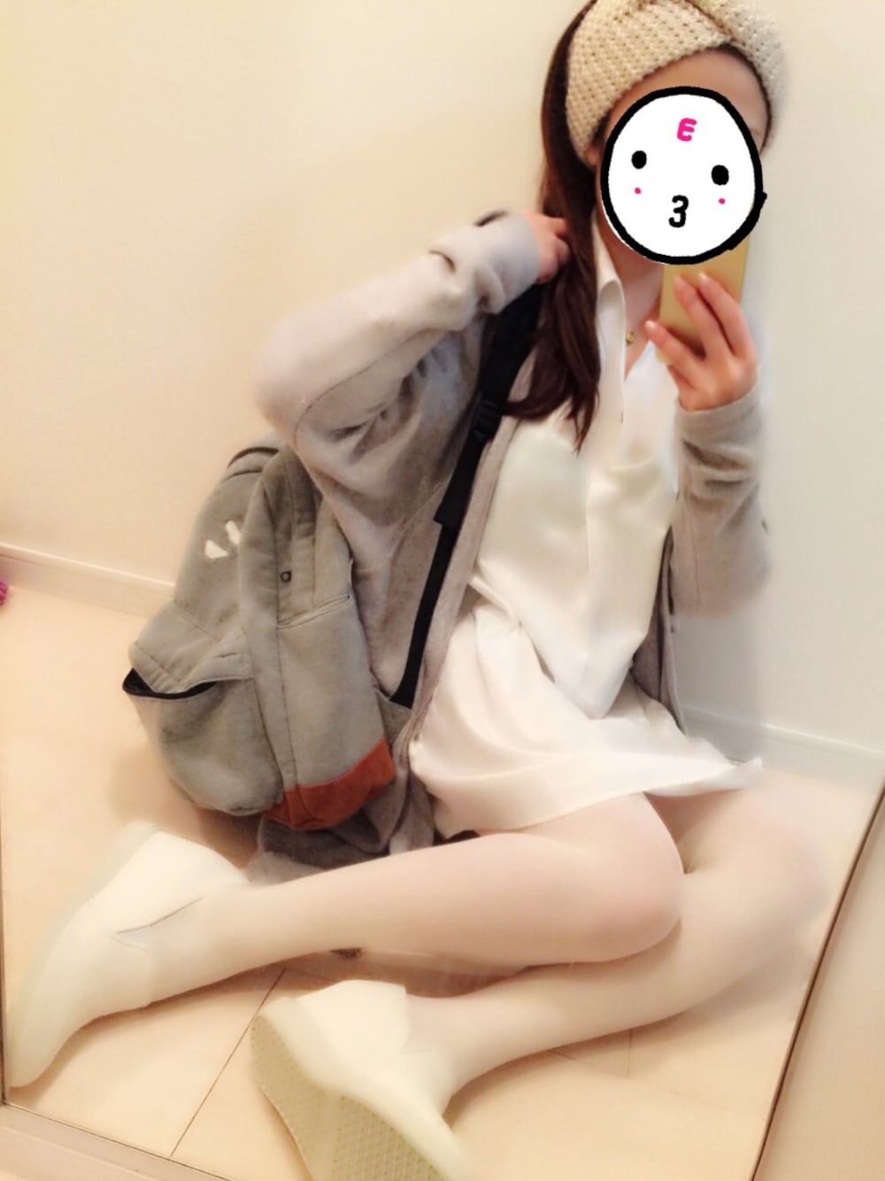 ホワイト系のワンピース、グレー系のカーディガン/ボレロ、グレー系のバックパック/リュックを着用したレディースの冬コーディネートの1枚目の写真