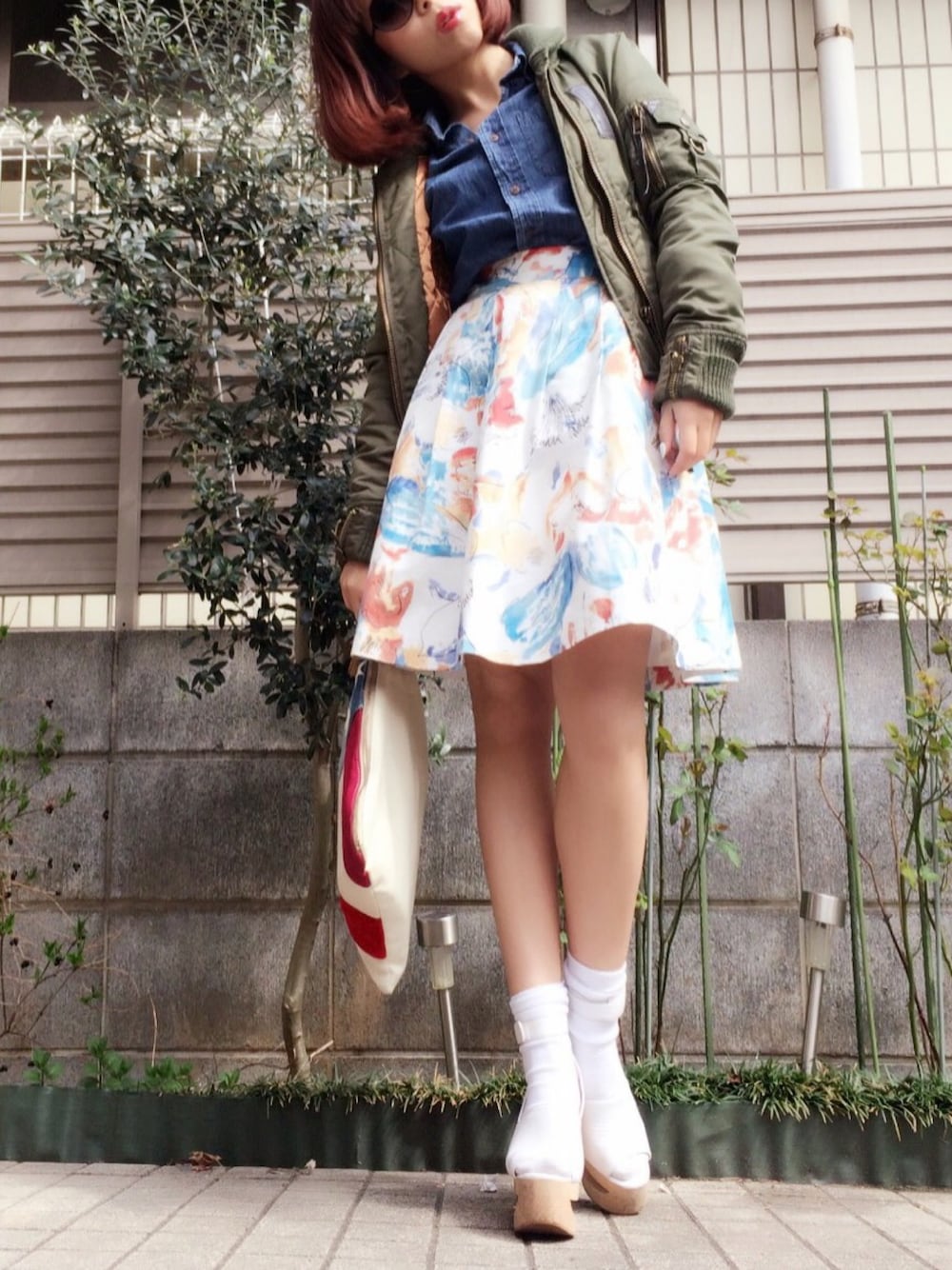 「dazzlin、花柄 スカート、MA-1、クラッチバッグ、デニムシャツ、ホワイトソックス、サングラス、靴下 × サンダル、フレアスカート」｜「dazzlinの水彩ﾎﾞﾘｭｰﾑｽｶｰﾄ（スカート、レッド系）」を使った、Ｍ Ｏ Ｅ Ｋ Ｏさん（レディース・150cm）の春コーディネートの1枚目の写真