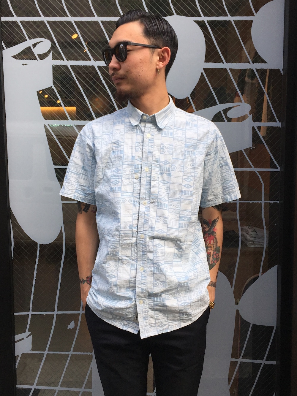 ブルー系のシャツ/ブラウス、ブラック系のチノパンツ、ブラック系のサングラスを着用したメンズの春コーディネートの1枚目の写真