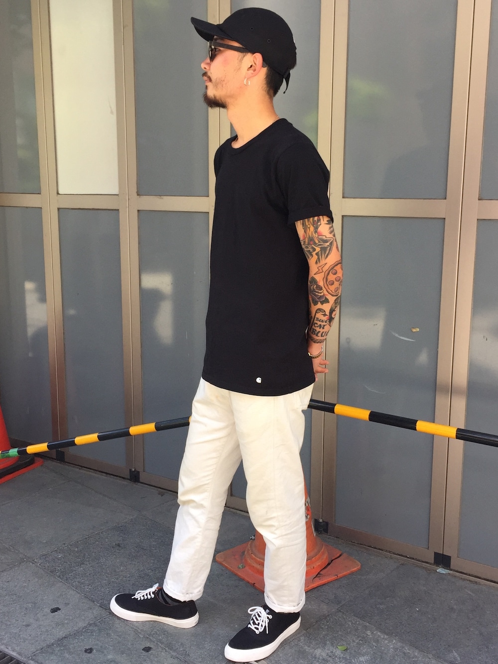 ブラック系のTシャツ/カットソー、ホワイト系のデニムパンツ、ブラック系のスニーカーを着用したメンズの夏コーディネートの1枚目の写真