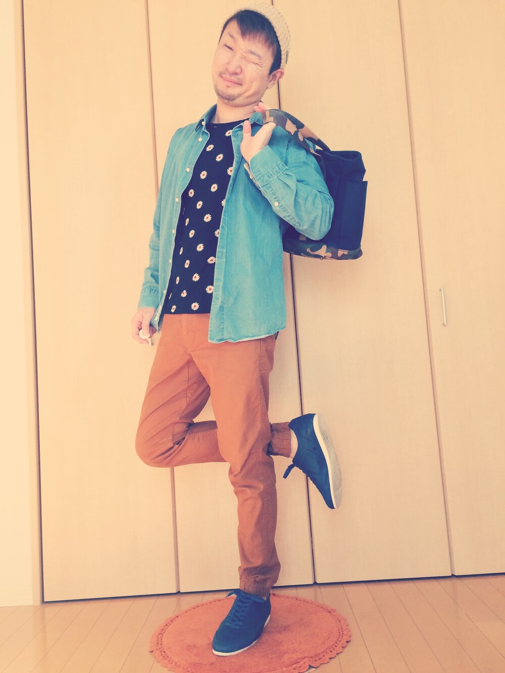 ブルー系のスニーカー、オレンジ系のチノパンツ、ブラック系のTシャツ/カットソーを着用したメンズの秋コーディネートの1枚目の写真