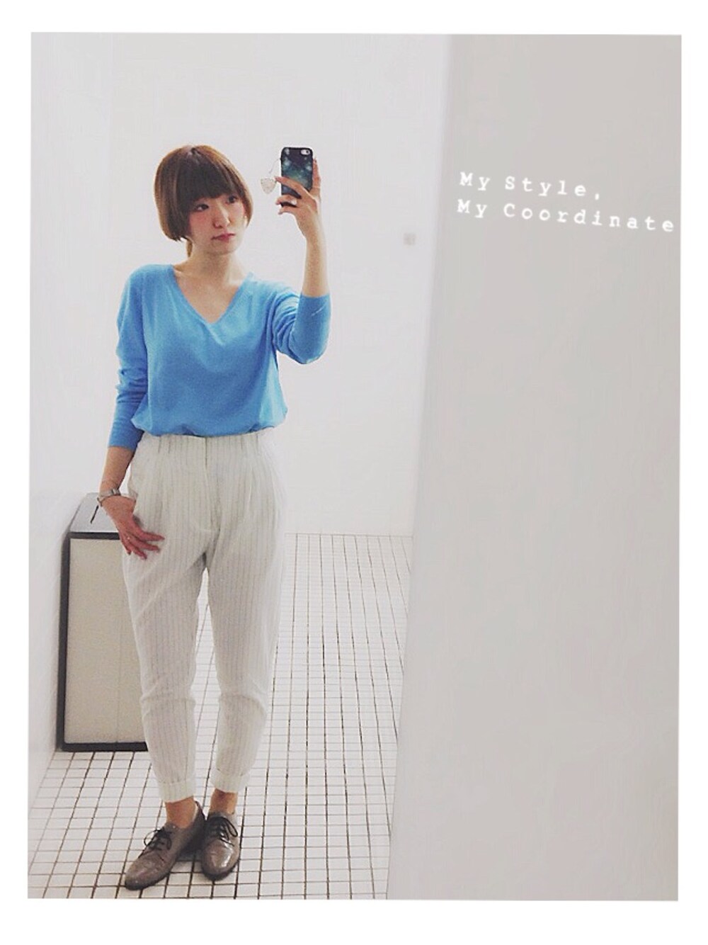 ホワイト系のパンツ、ブルー系のトップス、ベージュ系のパンプスを着用したレディースの冬コーディネートの1枚目の写真