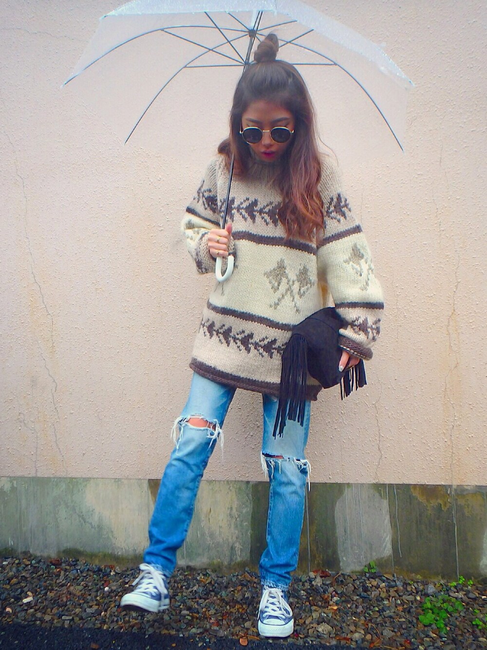 ブラック系のクラッチバッグ、ブルー系のデニムパンツ、ブルー系のスニーカーを着用したレディースの秋コーディネートの1枚目の写真