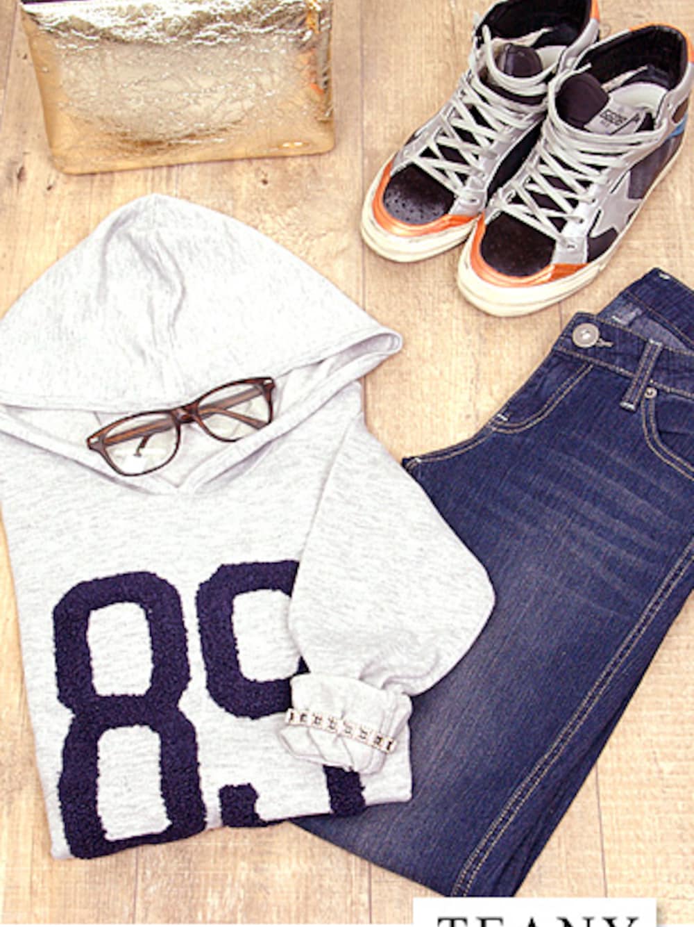 ホワイト系のニット/セーター、ブルー系のその他パンツ、ブラック系のクラッチバッグを着用したレディースの冬コーディネートの1枚目の写真