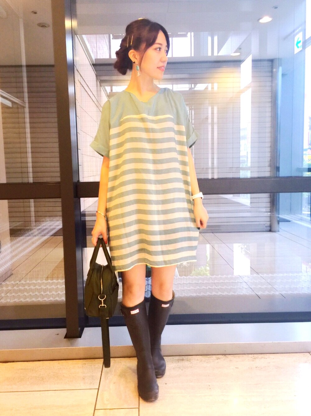 ブルー系のワンピース、グリーン系のハンドバッグ、ブラウン系のレインシューズを着用したレディースの夏コーディネートの1枚目の写真