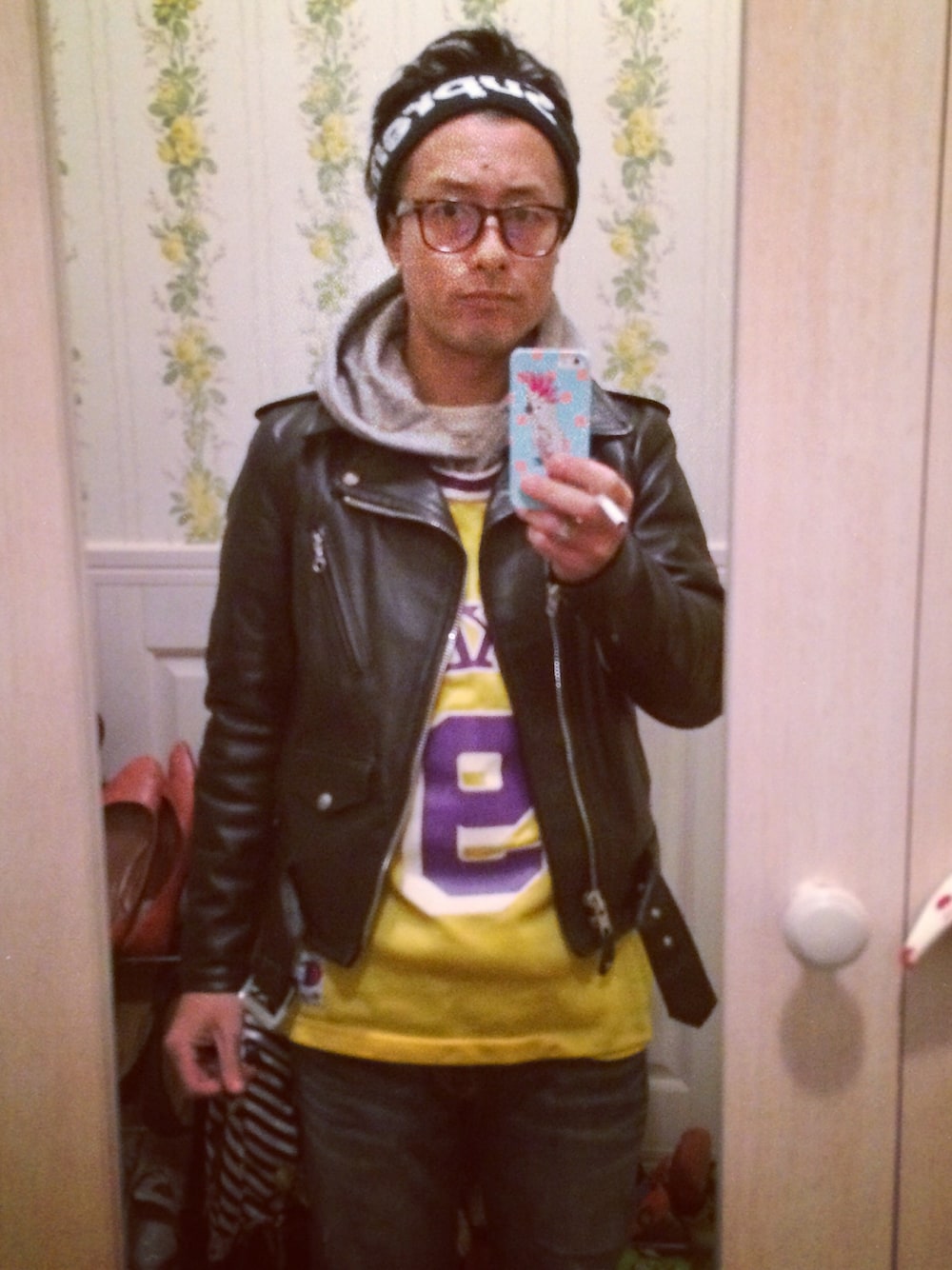 ブラック系のライダースジャケット、パープル系のスニーカー、イエロー系のタンクトップを着用したメンズの冬コーディネートの1枚目の写真