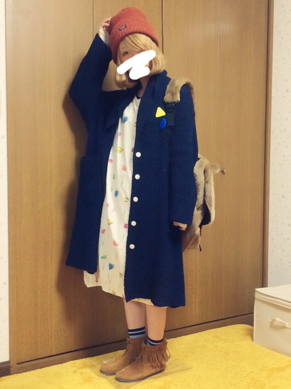 ブラック系のカーディガン/ボレロ、ホワイト系のワンピース/ドレス、ブラウン系のブーツを着用したレディースの冬コーディネートの1枚目の写真