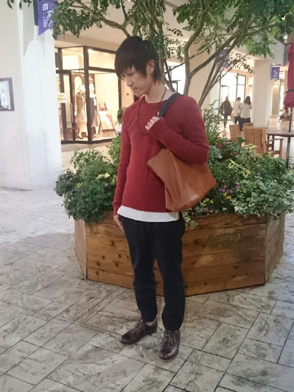 レッド系のニット/セーター、ブラウン系のトートバッグ、ホワイト系のTシャツ/カットソーを着用したメンズの秋コーディネートの1枚目の写真