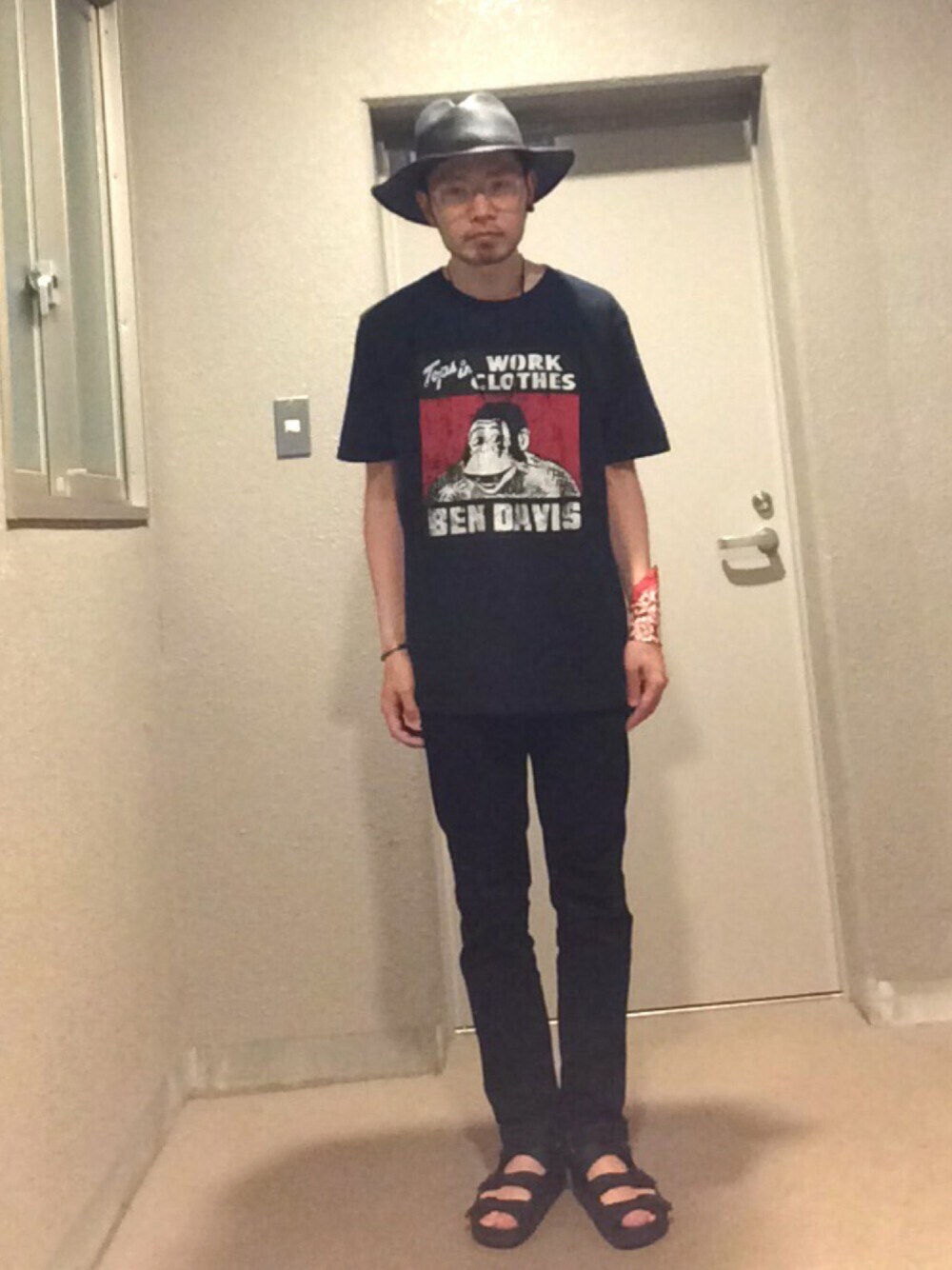 ブラック系のTシャツ/カットソー、ブラック系のデニムパンツ、ブラック系のサンダルを着用したメンズの春コーディネートの1枚目の写真