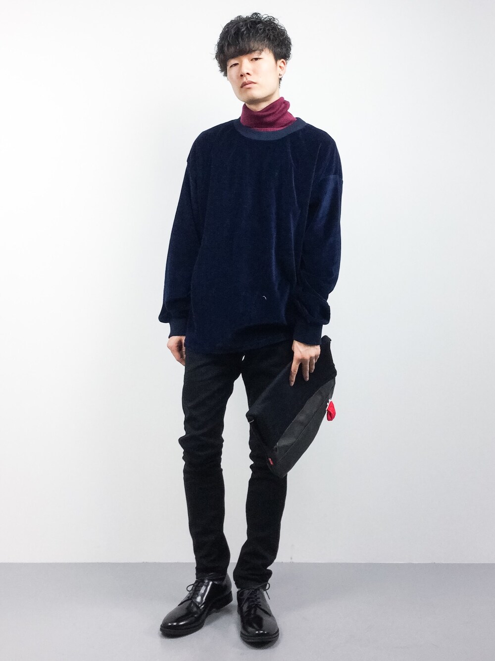 ブルー系のTシャツ/カットソー、ブラック系のクラッチバッグ、ブラック系のチノパンツを着用したメンズの秋コーディネートの1枚目の写真