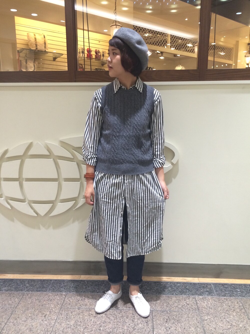 ブラック系のシャツワンピース、ブルー系のデニムパンツ、グレー系のハンチング/ベレー帽を着用したレディースの秋コーディネートの1枚目の写真