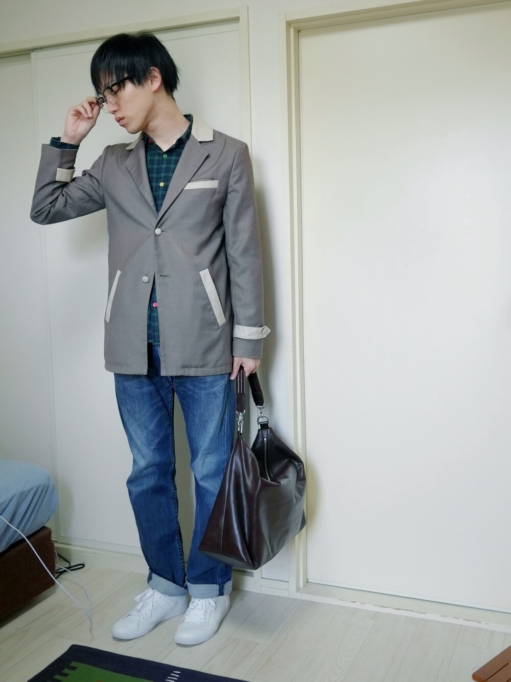 ブラウン系のトートバッグ、ブラック系のメガネを着用したメンズの春コーディネートの1枚目の写真