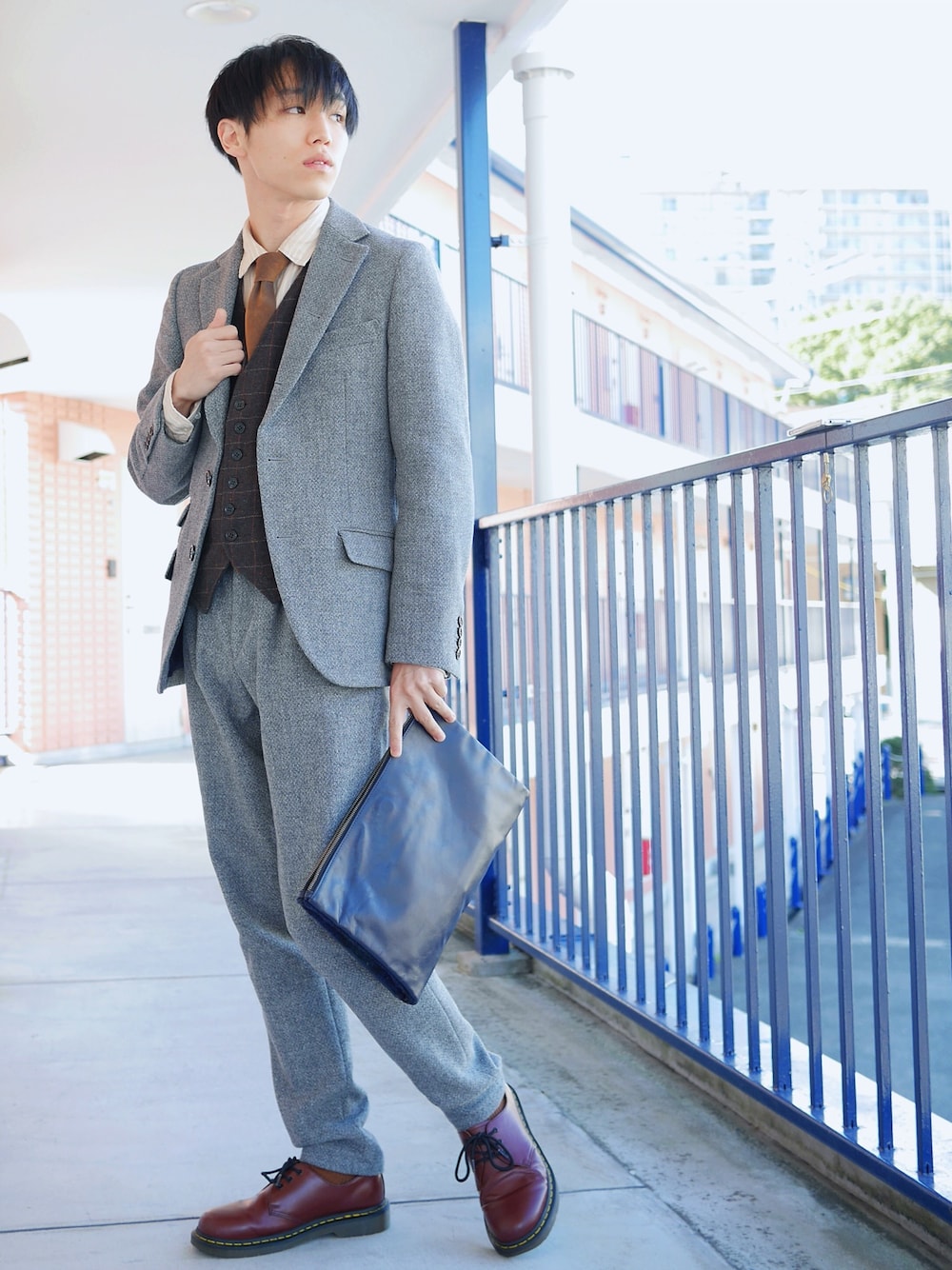 グレー系のテーラードジャケット、ベージュ系のシャツ/ブラウス、ブラウン系のベストを着用したメンズの冬コーディネートの1枚目の写真