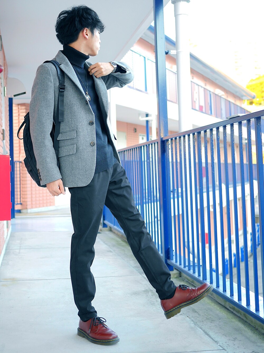 グレー系のテーラードジャケット、ブラック系のバックパック/リュック、ブラック系のニット/セーターを着用したメンズの冬コーディネートの1枚目の写真